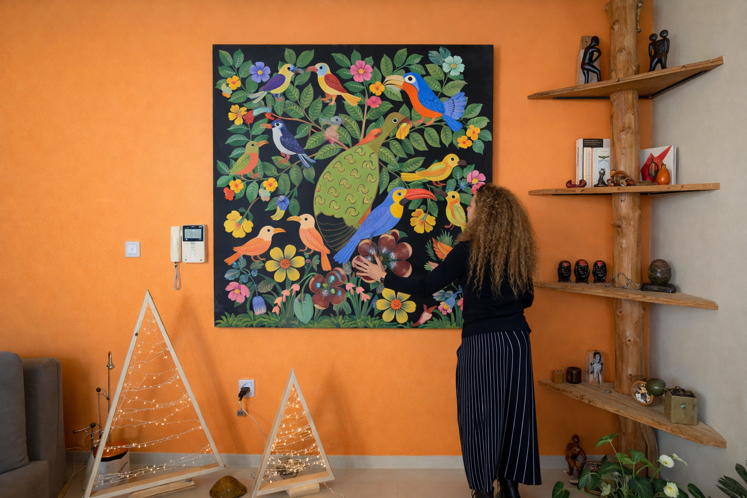 Happy customer hanging an african painting of birds that she bought from Tingatinga Art