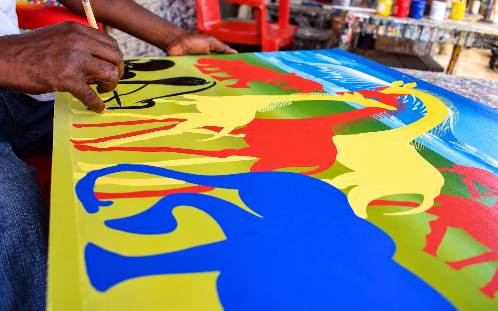 African artist hand-painting vibrant wildlife artwork in Tanzania