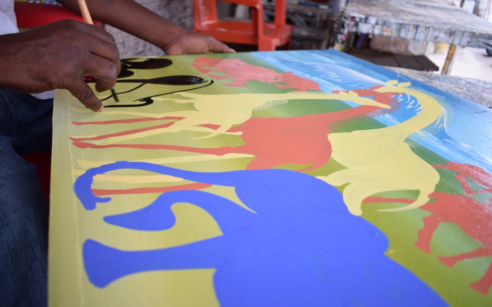 african painting of artist drawing